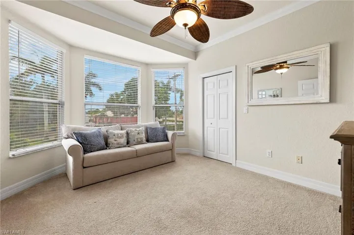Sitting room with carpet flooring, ornamental molding, and ceiling fan