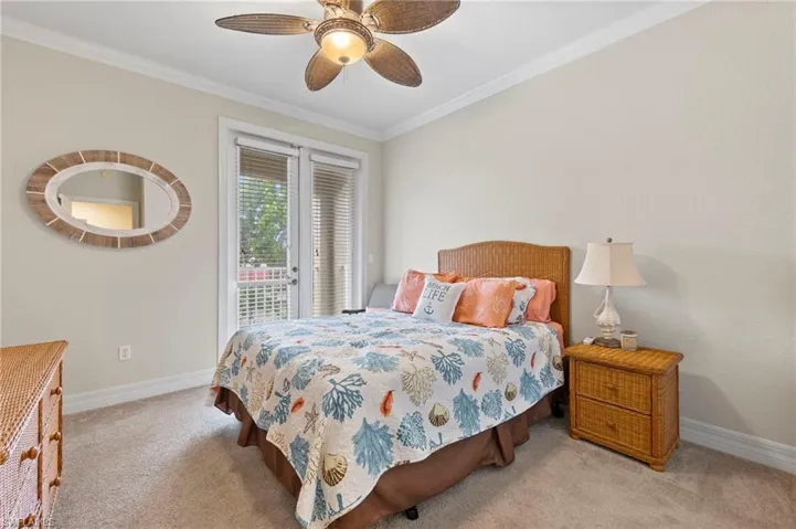 Bedroom featuring ceiling fan, ornamental molding, and carpet floors
