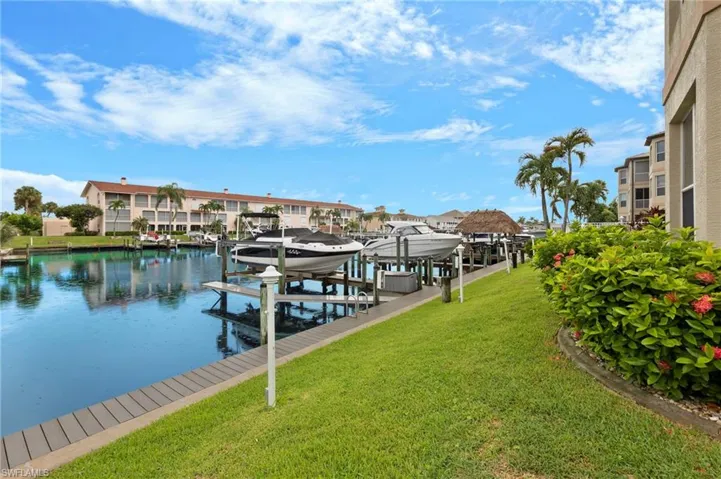 View of dock with a water view and a yard