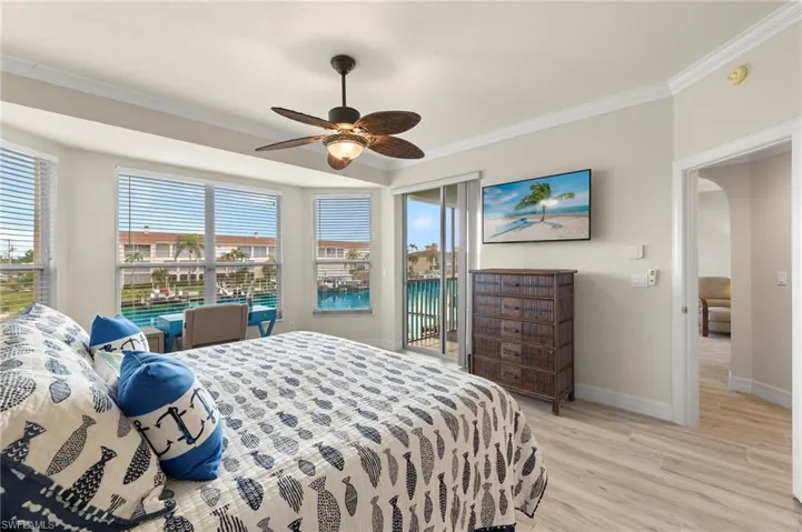 Bedroom featuring ornamental molding, ceiling fan, access to exterior, and light hardwood / wood-style flooring