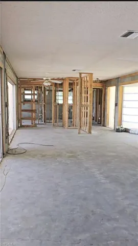 Unfurnished living room with a textured ceiling and concrete flooring