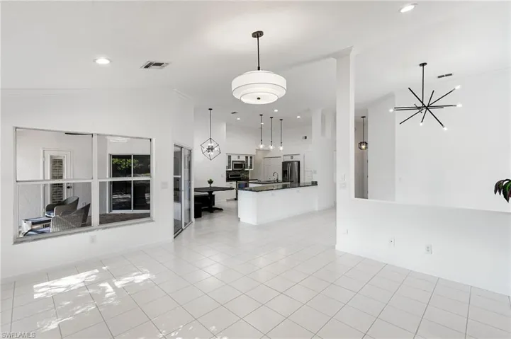Unfurnished living room with suspended lighting and light tile patterned floors