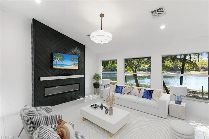 Virtually Staged-Living room featuring a large fireplace, crown molding, recessed lighting, and tile patterned floors