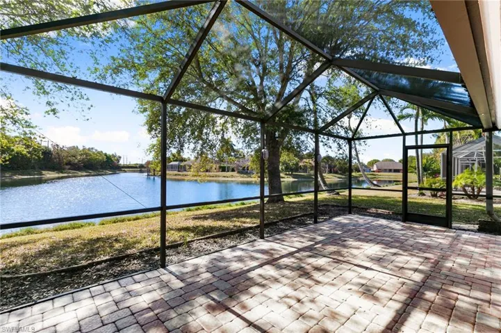Unfurnished sunroom with a water view and a patio area