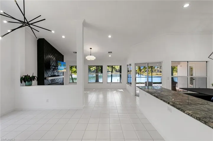 Unfurnished living room with recessed lighting, light tile patterned flooring, and lofted ceiling