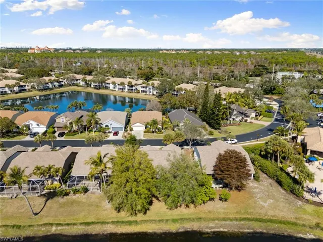Aerial perspective of suburban area featuring a large body of water and a tree filled landscape