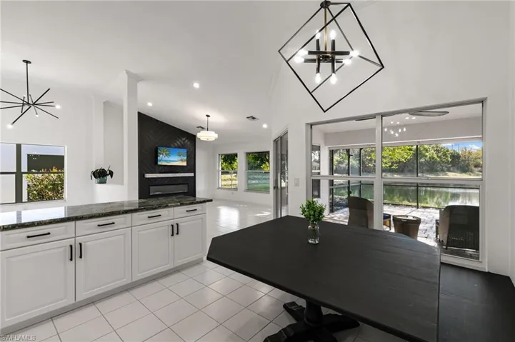 Dining space featuring hanging lights, vaulted ceiling, and light tile patterned floors
