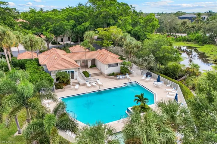 Community pool featuring a patio area, a pergola, a water view, and view of wooded area