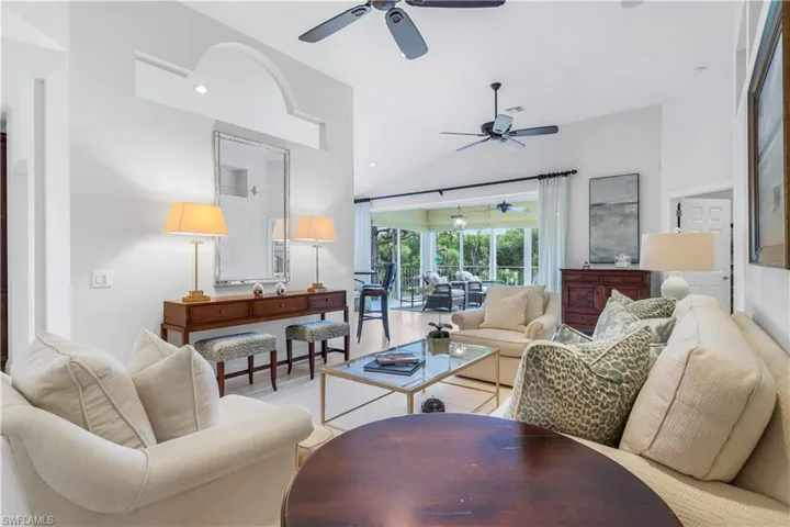 Living area featuring high vaulted ceiling, a sunroom, and ceiling fan