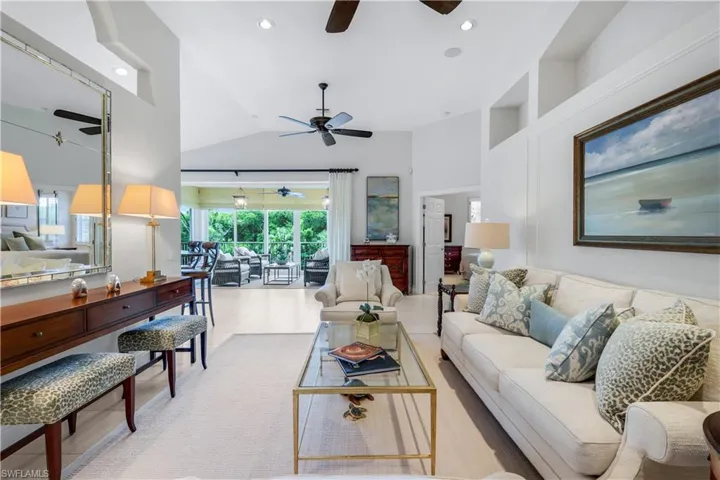 Tiled living area with recessed lighting and high vaulted ceiling