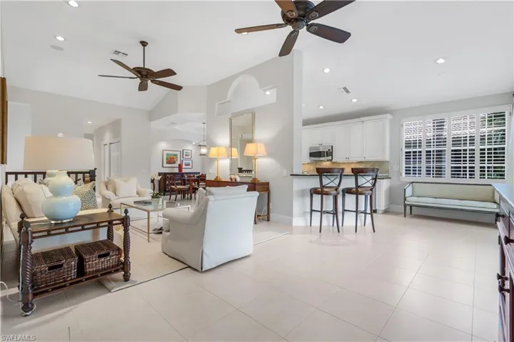 Living area featuring a ceiling fan, recessed lighting, light tile patterned floors, and high vaulted ceiling