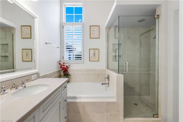 Bathroom featuring vanity, a shower stall, and a bath