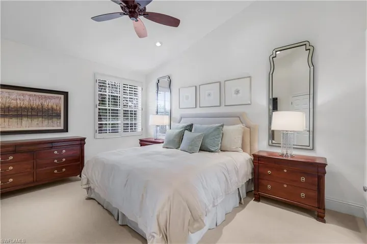 Carpeted bedroom featuring lofted ceiling, ceiling fan, and recessed lighting