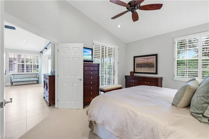 Bedroom featuring vaulted ceiling, recessed lighting, ceiling fan, light tile patterned floors, and light carpet