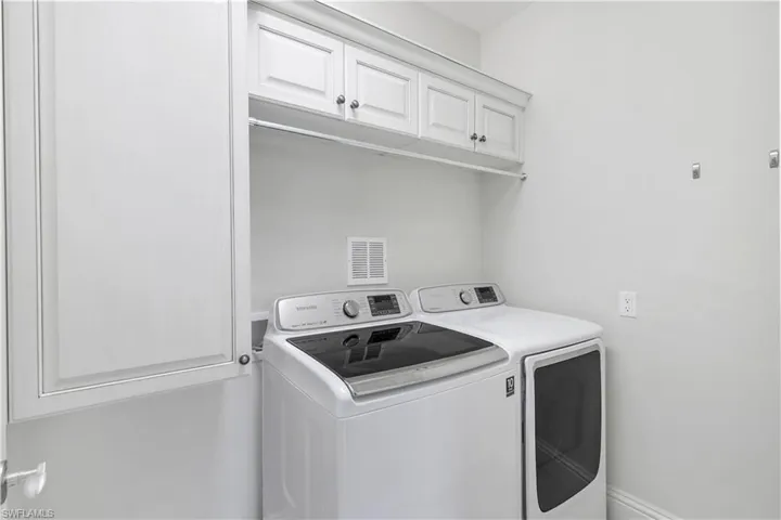 Washroom with washing machine and clothes dryer and cabinet space