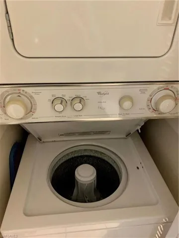 Laundry room featuring stacked washing machine and dryer