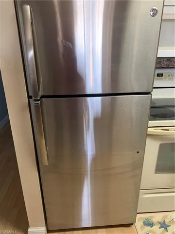 Kitchen view of freestanding refrigerator and stove