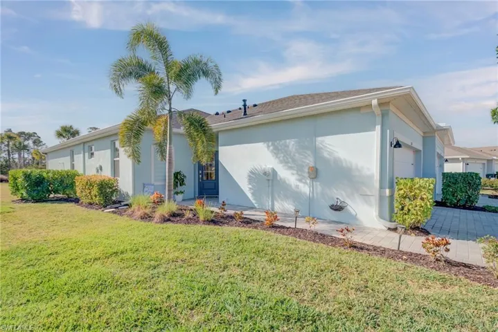 View of side of home featuring stucco siding, a yard, and an attached garage