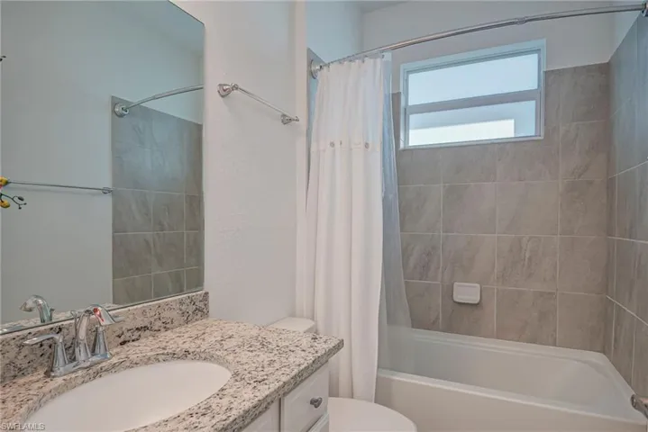 Full bath featuring vanity and shower / bath combination with curtain