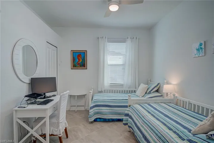 Bedroom with a ceiling fan and light tile patterned flooring