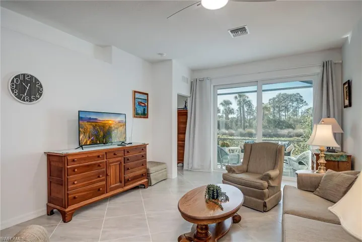 Living area featuring light tile patterned floors and a ceiling fan