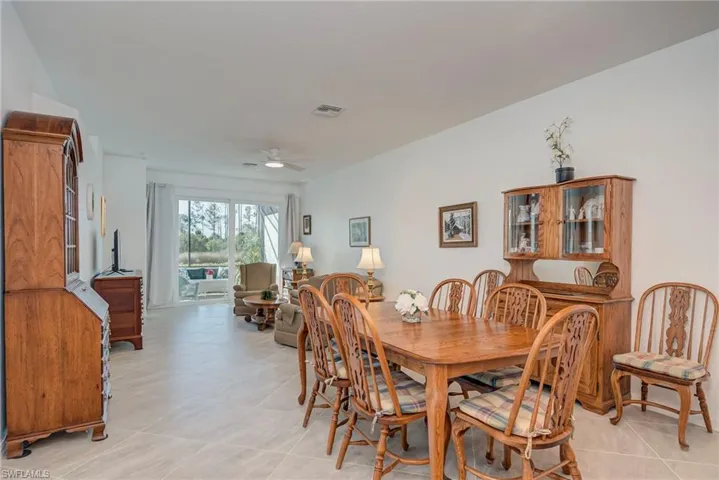 Dining space with ceiling fan and light tile patterned flooring