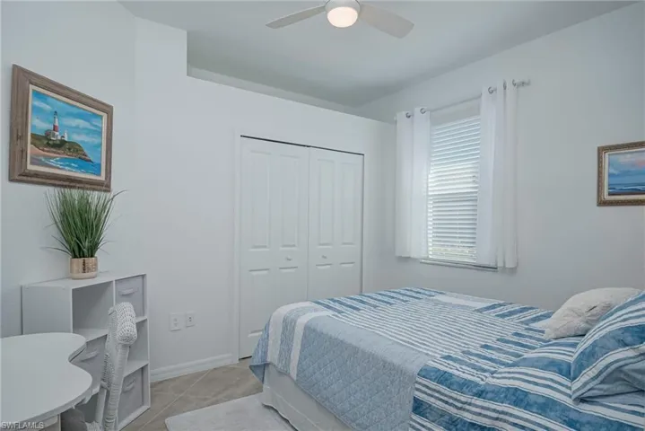 Bedroom featuring a ceiling fan, a closet, and tile patterned flooring
