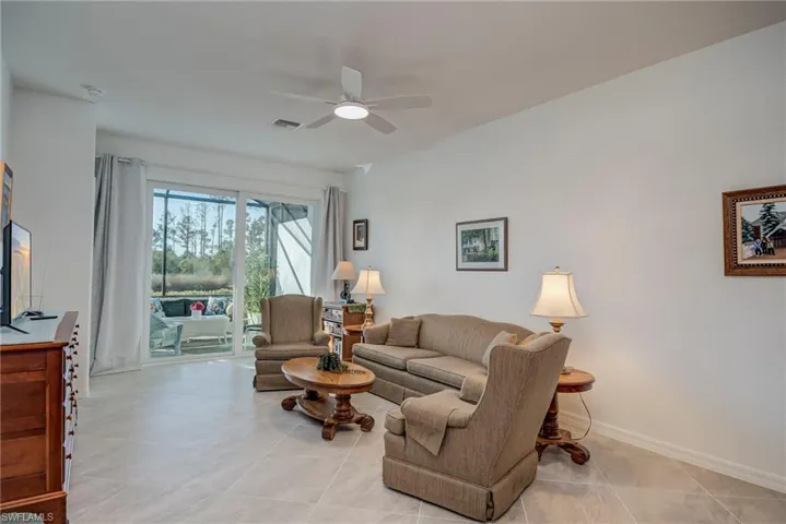 Living room featuring ceiling fan and baseboards