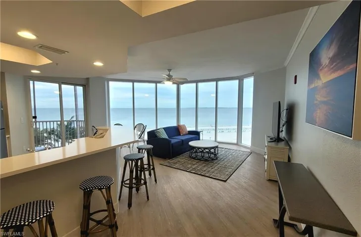 Living room featuring a ceiling fan, a wall of windows, light wood-style flooring, visible vents, and recessed lighting