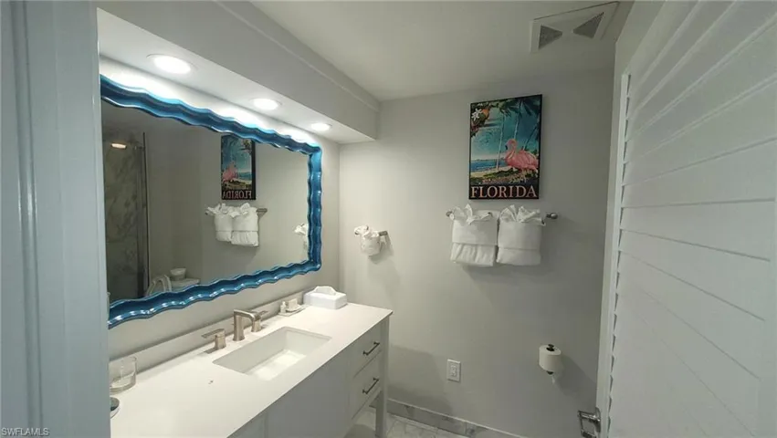 Bathroom with marble finish floor, vanity, baseboards, and visible vents
