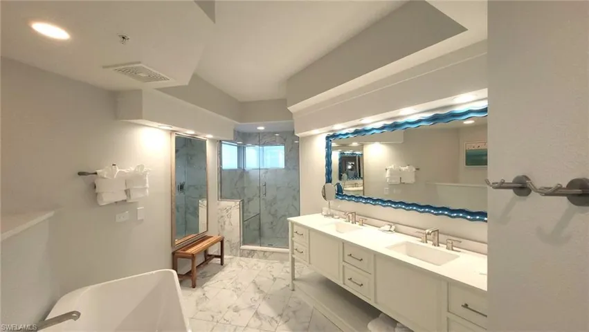 Full bathroom with marble finish floor, a sink, a marble finish shower, and visible vents