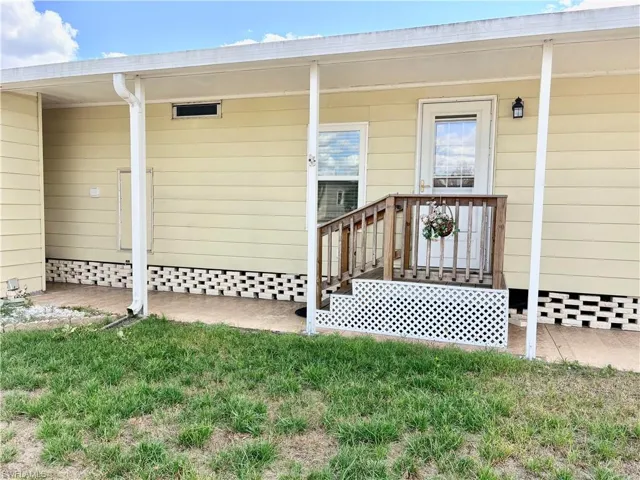 View of exterior entry featuring a yard
