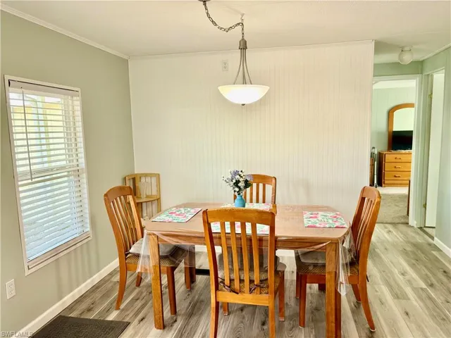 Dining space featuring light wood-type flooring and crown molding