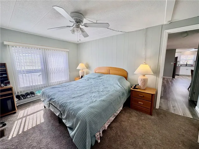 Bedroom with carpet, a textured ceiling, and a ceiling fan