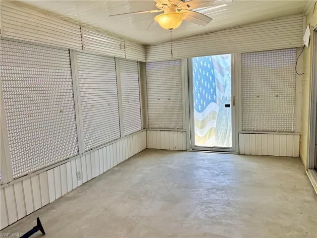 Unfurnished sunroom featuring a ceiling fan