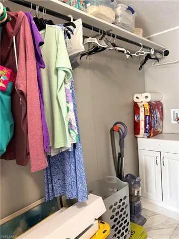 Walk in closet with light marble finish flooring