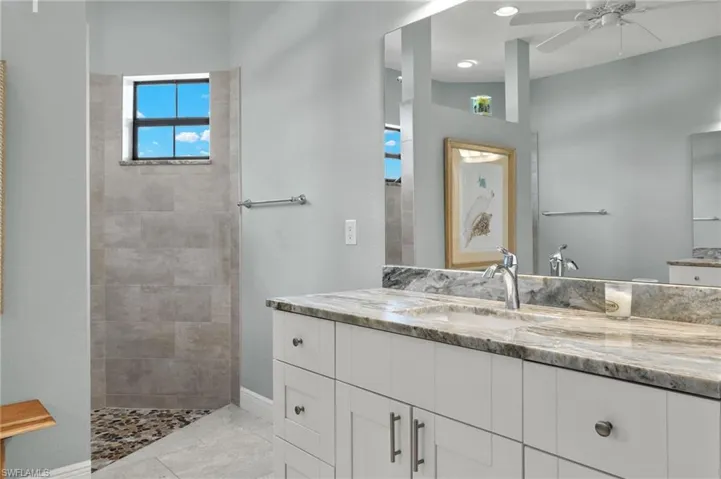 Bathroom featuring vanity, ceiling fan, and tile patterned floors