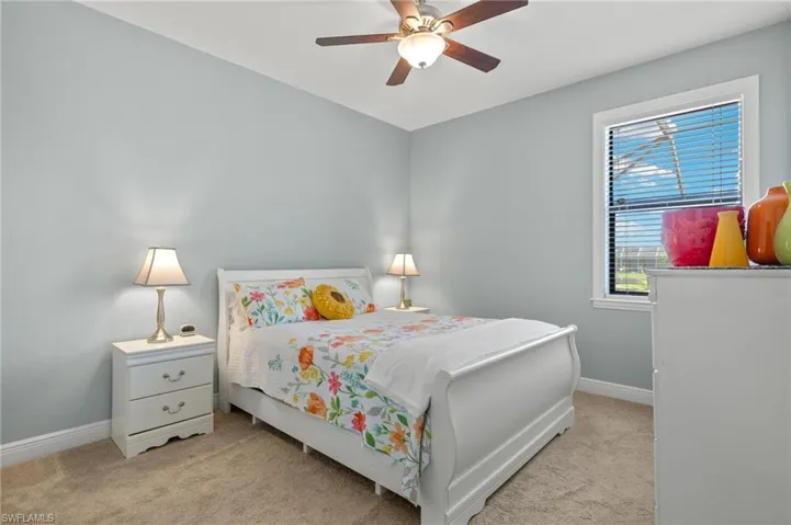 Carpeted bedroom featuring ceiling fan