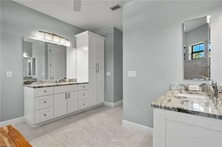 Bathroom with vanity, tile patterned flooring, and ceiling fan