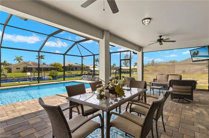 View of patio with outdoor lounge area, ceiling fan, and glass enclosure