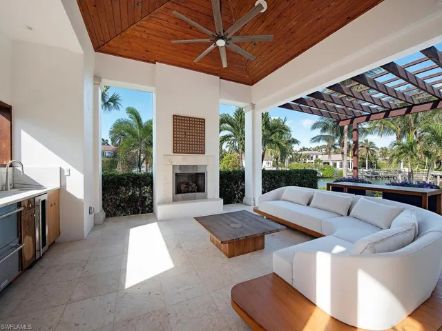 View of patio / terrace with an outdoor living space with a fireplace, ceiling fan, sink, and a water view