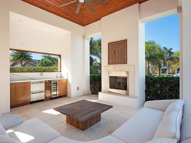 View of patio with an outdoor living space with a fireplace, ceiling fan, beverage cooler, and exterior kitchen