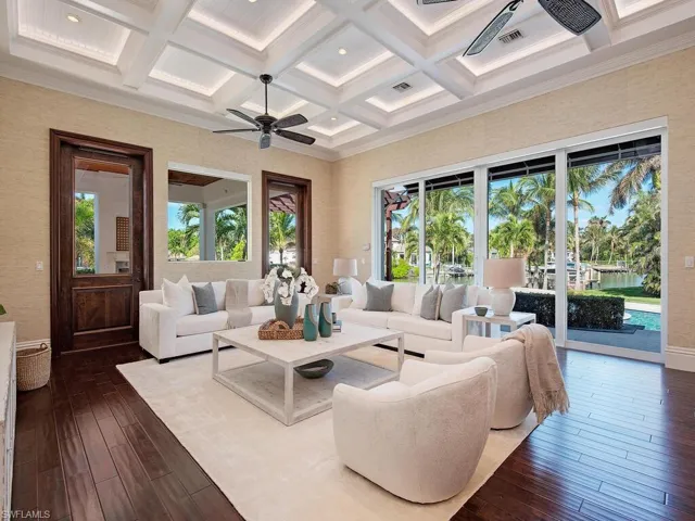 Living room with ceiling fan, coffered ceiling, beamed ceiling, hardwood / wood-style flooring, and ornamental molding