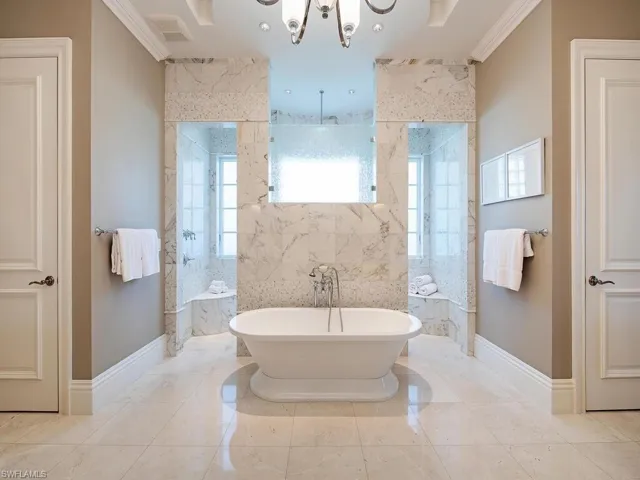 Bathroom with tile patterned flooring, shower with separate bathtub, an inviting chandelier, and ornamental molding