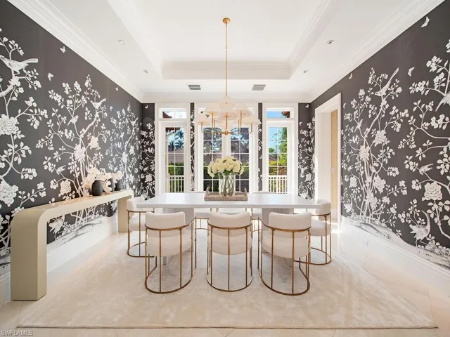 Dining space featuring a tray ceiling, ornamental molding, and an inviting chandelier