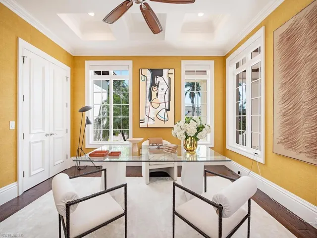 Home office featuring ceiling fan, hardwood / wood-style floors, coffered ceiling, and ornamental molding