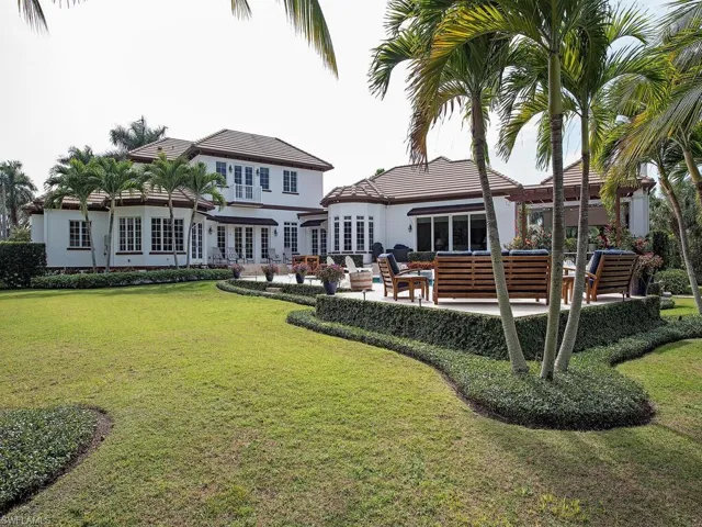 Rear view of house featuring a lawn, an outdoor living space, and a patio