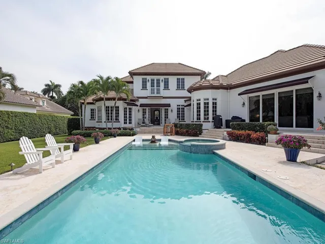 Back of property with french doors, a patio, and a swimming pool with hot tub