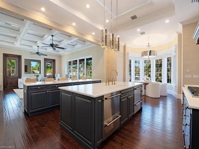 Kitchen featuring a center island, coffered ceiling, decorative light fixtures, beam ceiling, and dark hardwood / wood-style flooring