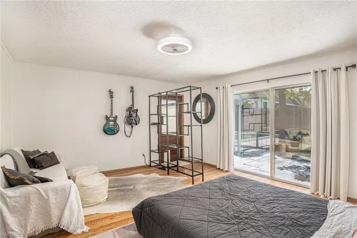 Bedroom featuring access to exterior, a textured ceiling, and hardwood / wood-style flooring